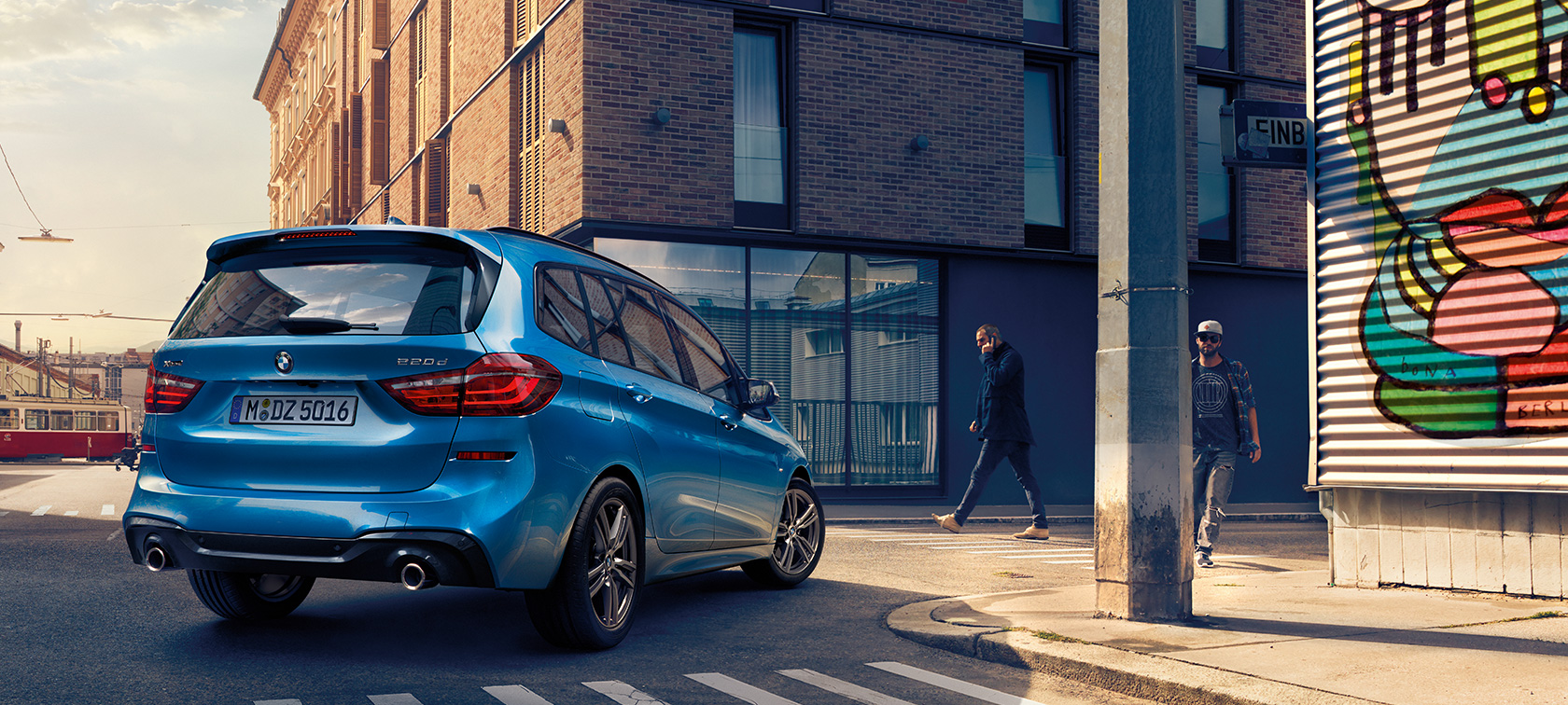 Man next to BMW 2 Series Gran Tourer F46 2018 Estoril Blue metallic bird’s-eye view parking on the street