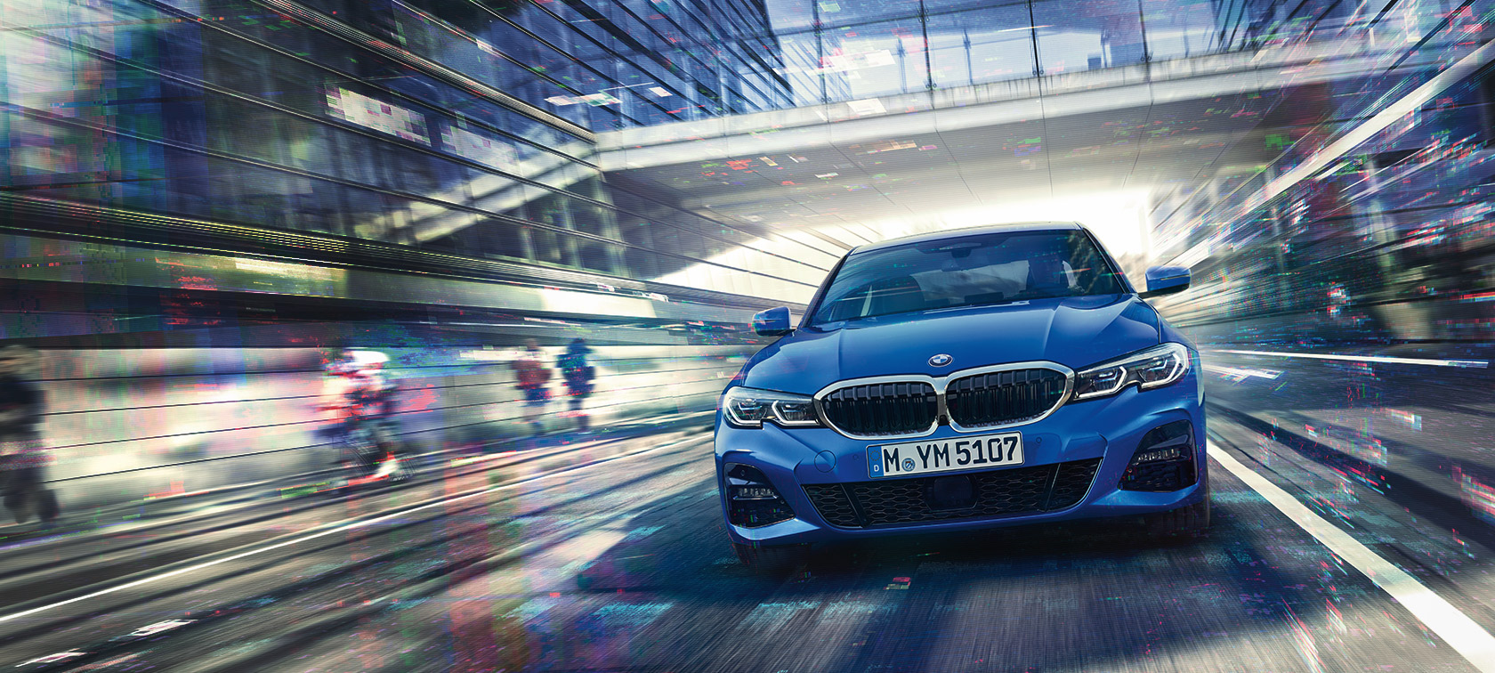 Front view of driving BMW 3 Series Sedan (G20) by day under glass building.